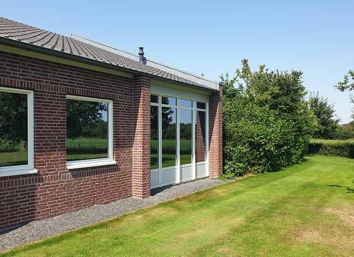 Stijlvolle zithoek met open haard in Vakantiehuis in Schaijk, Noord Brabant, ideaal voor ontspanning.
