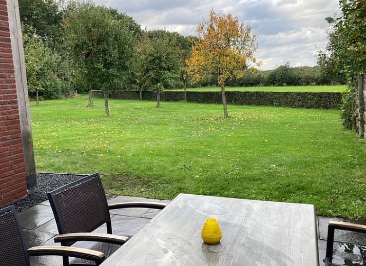 Stijlvolle zithoek met open haard in Vakantiehuis in Schaijk, Noord Brabant, ideaal voor ontspanning.