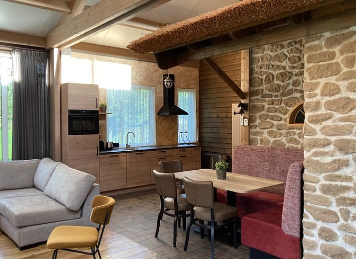 Ruime slaapkamer met grote ramen in Vakantiehuis in Schaijk, omgeven door groene natuur in Noordoost Brabant.