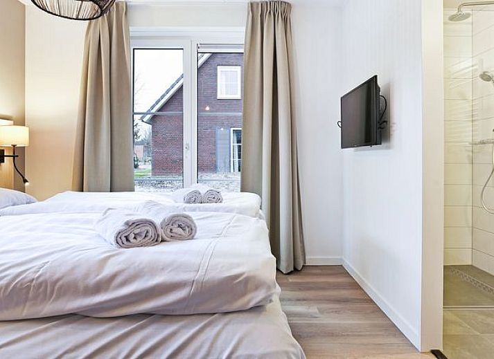 Moderne woonkamer in De Vers 6-persoons kinderbungalow Overloon met eetgedeelte en open keuken.