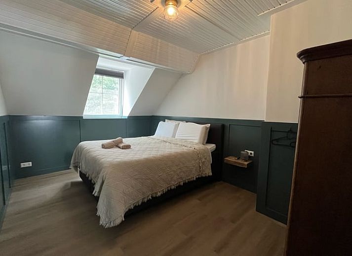 Ruime picknicktafel onder bomen bij Vakantiehuis in Overloon, perfect voor buitenmaaltijden in Noord Brabant.