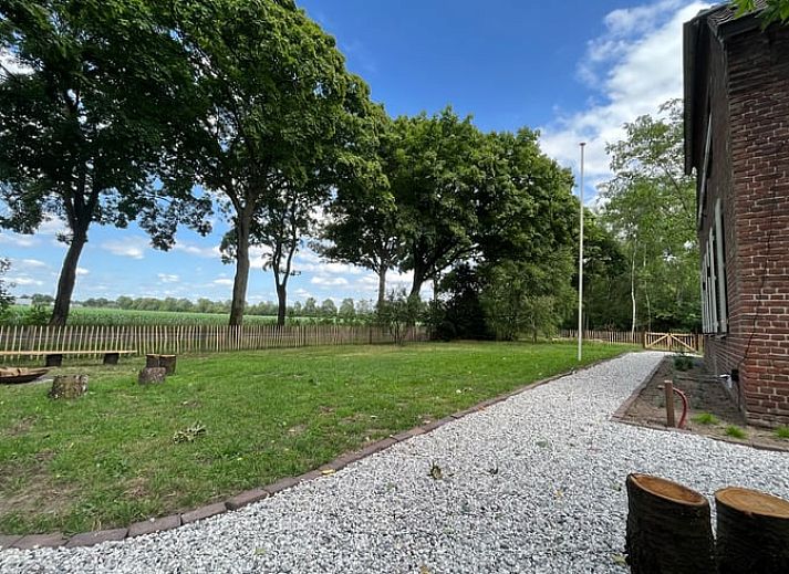Rustieke hot tub in de tuin van Vakantiehuis in Overloon, omringd door groene natuur voor ultieme ontspanning.
