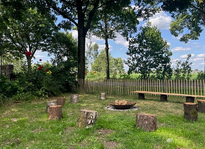 Rustieke hot tub in de tuin van Vakantiehuis in Overloon, omringd door groene natuur voor ultieme ontspanning.