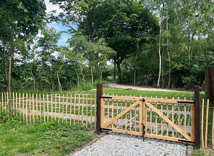 Rustieke hot tub in de tuin van Vakantiehuis in Overloon, omringd door groene natuur voor ultieme ontspanning.