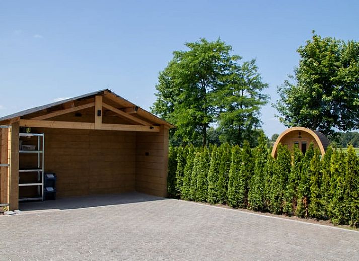 Zicht op tuin en lodge bij Vakantiehuis in Overloon, Noordoost Brabant, met wandelpad en groene natuur.