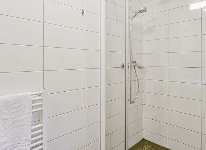 Moderne woonkamer in De Vers 6-persoons bungalow 6C2, Overloon, met open keuken en houten vloer.