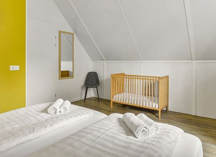 Comfortabele zithoek in De Vers 6-persoons bungalow 6C2, Overloon, met gele accenten en ruime bank.