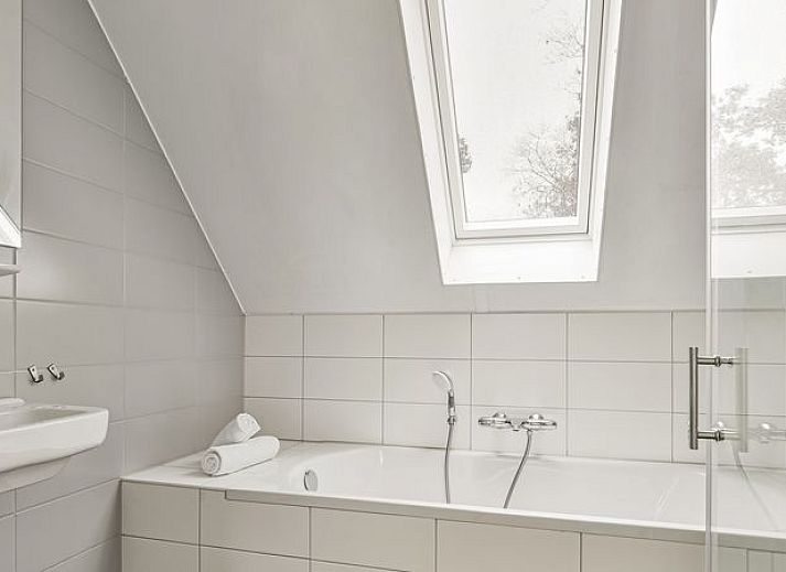 Comfortabele zithoek in De Vers 6-persoons bungalow 6C2, Overloon, met gele accenten en ruime bank.