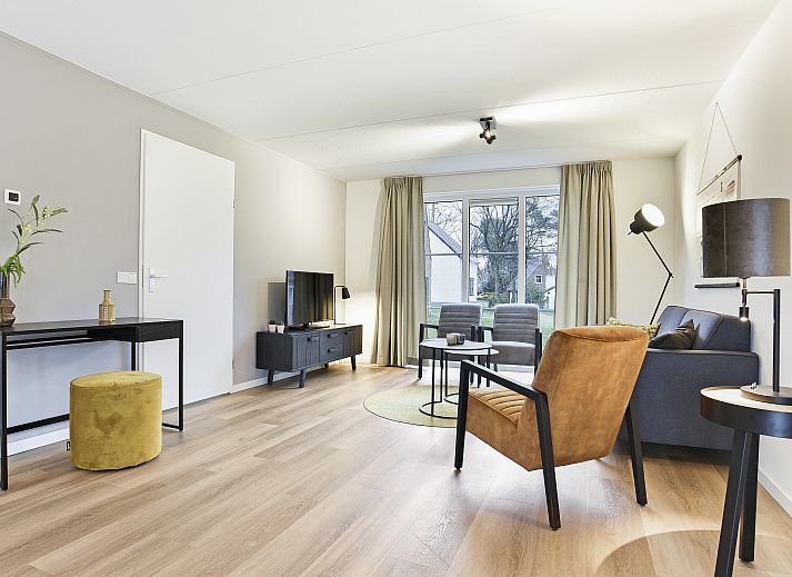 Cozy living room of De Vers bungalow in Overloon, northeast Brabant with modern decor and garden views.