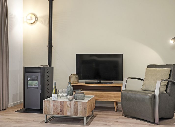 Stijlvolle zithoek in De Vers 2-persoons bungalow 2L, Overloon, met comfortabele stoelen en een flatscreen-tv.