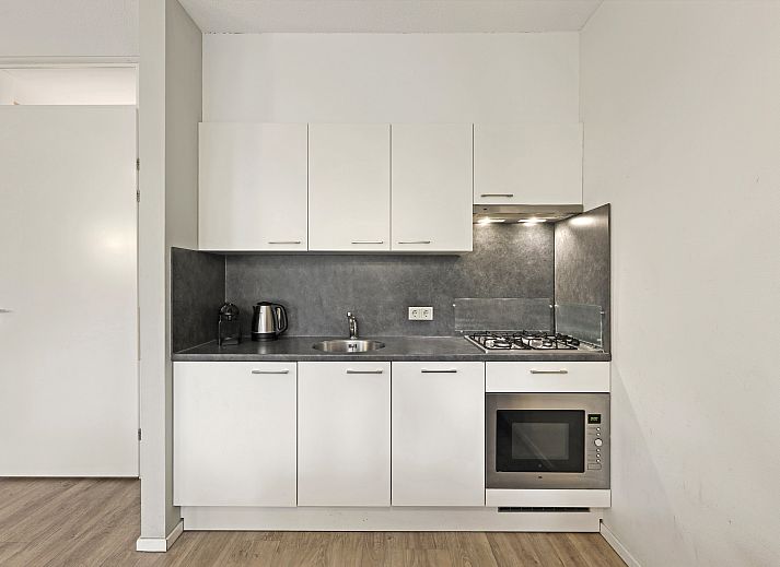 Moderne woonkamer met pelletkachel in De Vers 2-persoons bungalow 2L, Overloon, Noordoost Brabant.