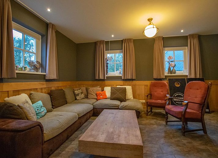 Geraeumiges Wohnzimmer der Lodge Slabroek in Uden, Nordbrabant, mit bequemen Sitzgelegenheiten und salonartiger Bestuhlung.