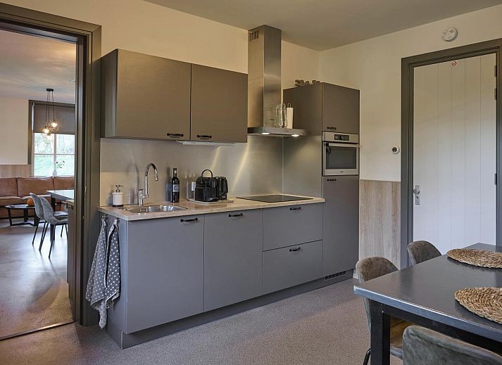 Gezellige woonkamer in vakantiehuis Bosbeertje 43 45, Erp, Noord Brabant met comfortabele bank en natuurlijke lichtinval.