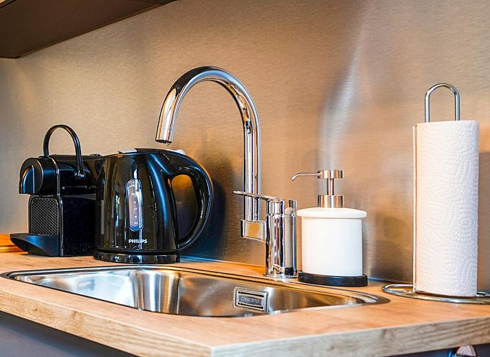 Gezellige woonkamer in vakantiehuis Bosbeertje 43 45, Erp, Noordoost Brabant, met comfortabele zithoek en sfeervolle verlichting.