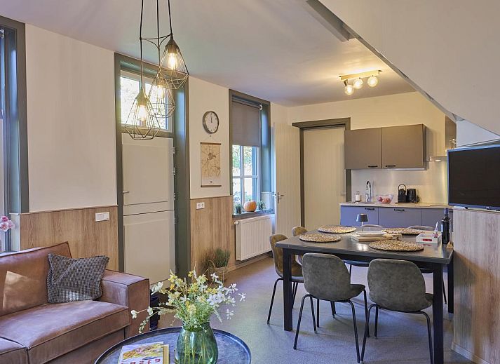 Gezellige woonkamer in vakantiehuis Bosbeertje 43 45, Erp, Noordoost Brabant, met comfortabele zithoek en sfeervolle verlichting.