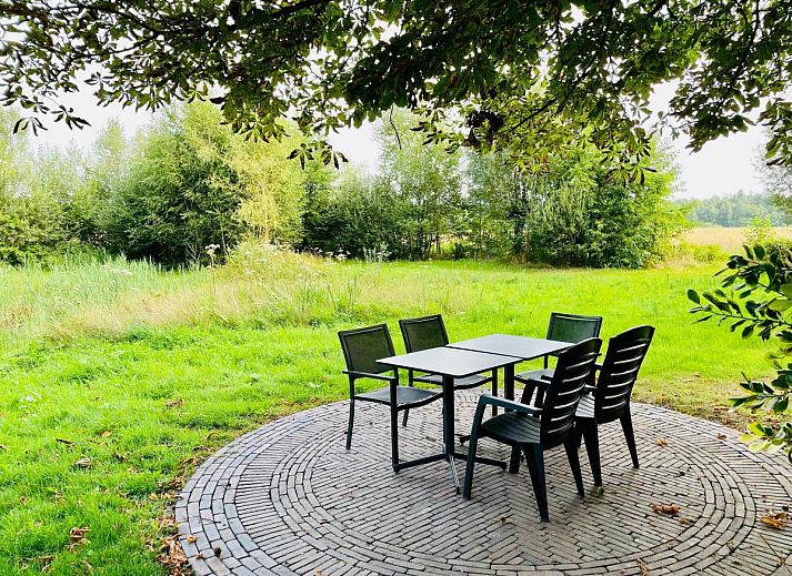 Gezellige woonkamer van vakantiehuis Bosbeertje 43 45 in Erp, Noordoost Brabant, met comfortabele bank en sfeervolle verlichting.