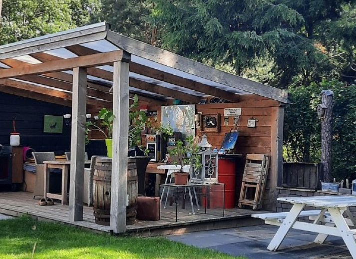 Veranda met picknicktafel bij bungalow Grove Den in Sint-Oedenrode, Noord Brabant, omgeven door groen.