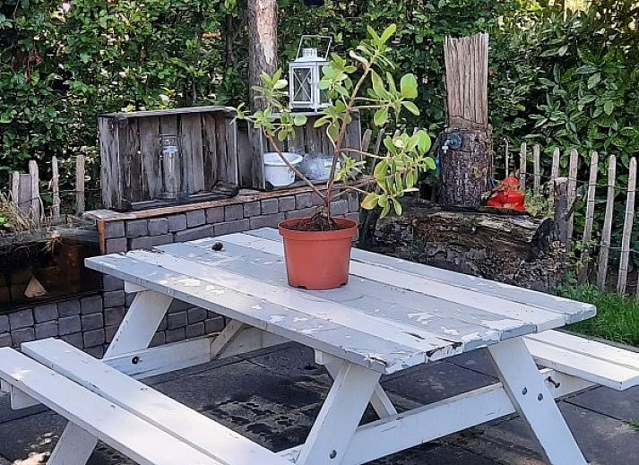 Veranda met picknicktafel bij bungalow Grove Den in Sint-Oedenrode, Noord Brabant, omgeven door groen.