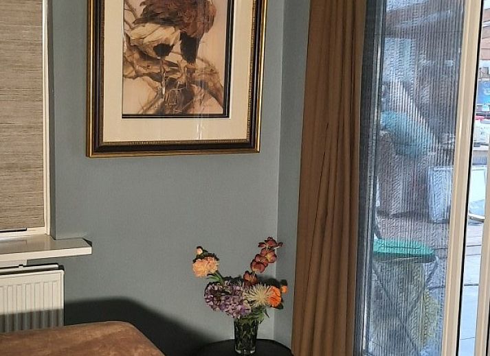 Achtertuin van vakantiehuis Grove Den in Sint-Oedenrode, Noord Brabant, met uitzicht op het grasveld en bomen.