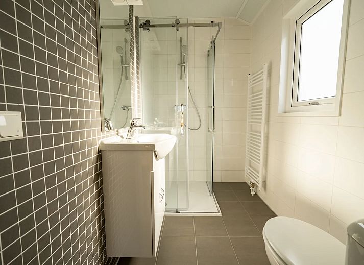 Cozy living room of detached house in Linden, Northeast Brabant, with views of nature through large windows.