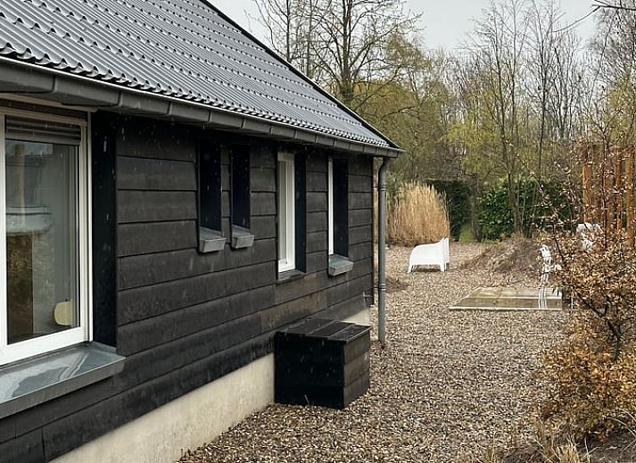 Gezellige zithoek in Vakantiehuisje in Beers, Noord Brabant, met comfortabele bank en groene planten.