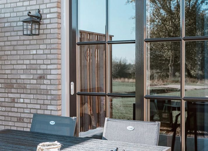 Stijlvol ingerichte zithoek in Vakantiehuisje in Sint-Oedenrode, Noordoost Brabant met kunst aan de muur.