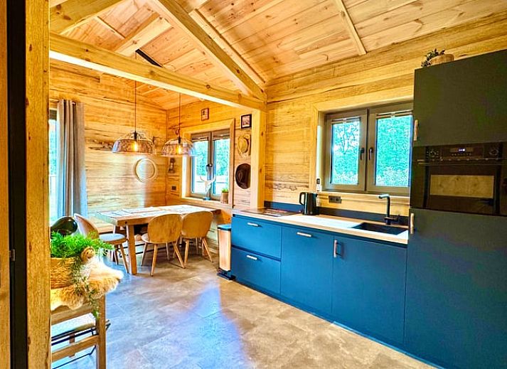 Cozy wooden cottage in Ledeacker Northeast Brabant with porch and seating area, surrounded by nature.