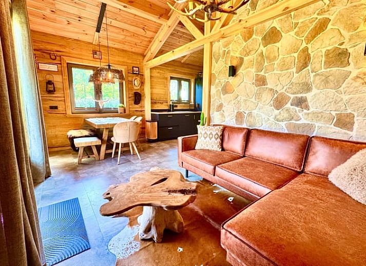 Cozy wooden cottage in Ledeacker Northeast Brabant with porch and seating area, surrounded by nature.