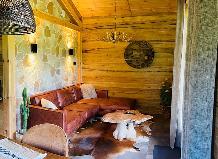 Cozy living room in cottage in Ledeacker, northeast Brabant, with wooden interior and comfortable seating area.