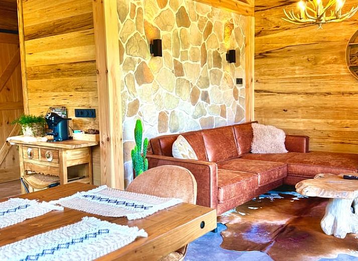 Cozy living room in cottage in Ledeacker, northeast Brabant, with wooden interior and comfortable seating area.