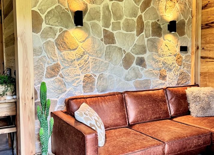 Cozy living room in cottage in Ledeacker, northeast Brabant, with wooden interior and comfortable seating area.