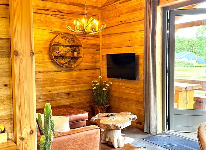 Cozy living room in cottage in Ledeacker, northeast Brabant, with wooden interior and comfortable seating area.