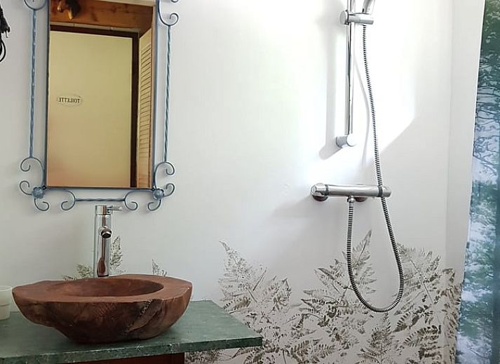 Terras met tuintafel in Vakantiehuis Ossendrecht, omringd door groene natuur in West Brabant.