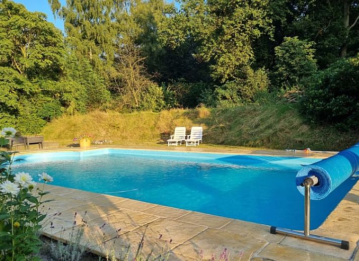 Veranda met uitzicht op zwembad in Vakantiehuis Ossendrecht, perfect voor buiten dineren in Noord Brabant.