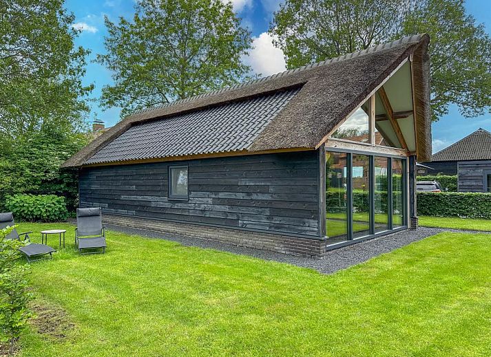 Villa Brocante vacation home in Alphen, North Brabant with thatched roof and terrace for relaxation.