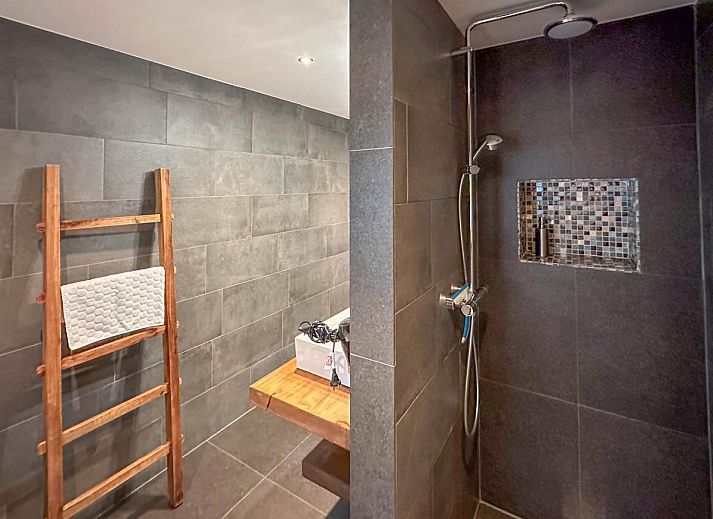 Spacious living room of Villa Brocante in Alphen, vacation home with wooden beams and open kitchen.