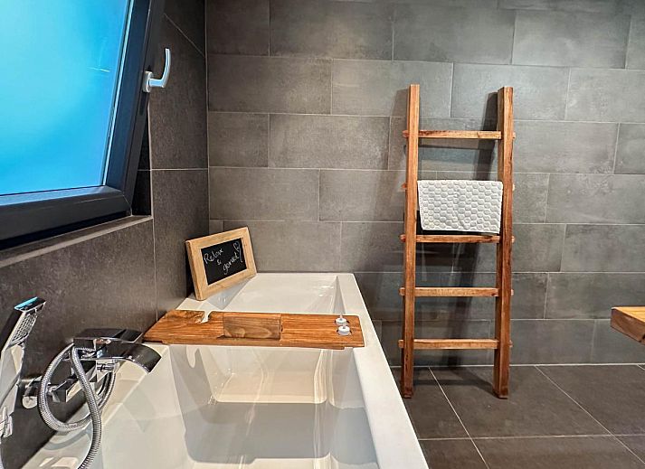 Spacious living room of Villa Brocante in Alphen, vacation home with wooden beams and open kitchen.