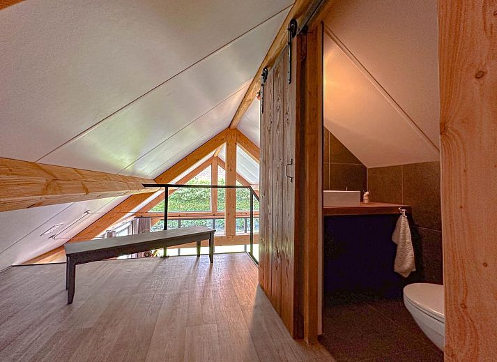 Spacious living room of Villa Brocante in Alphen, vacation home with wooden beams and open kitchen.