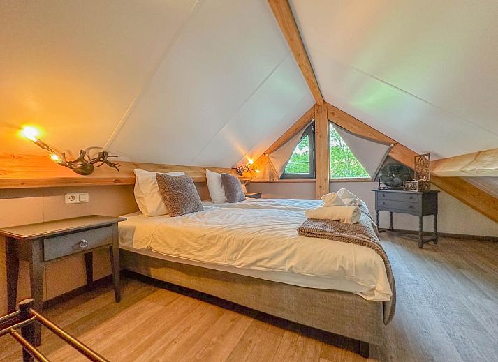 Spacious living room of Villa Brocante in Alphen, vacation home with wooden beams and open kitchen.
