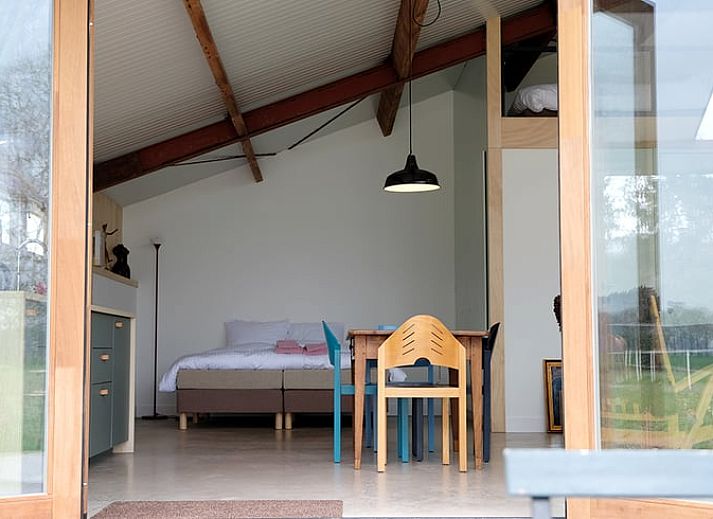 Gemuetliches Interieur eines Ferienhauses in Gilze mit Blumen und Wein, Westbrabant.