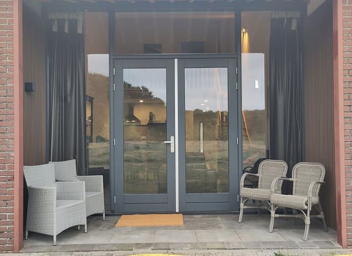 Gemuetliches Wohnzimmer von Huisje in Rucphen, Ferienhaus in Westbrabant, mit Blick auf die gruene Natur vom geraeumigen Innenbereich aus.