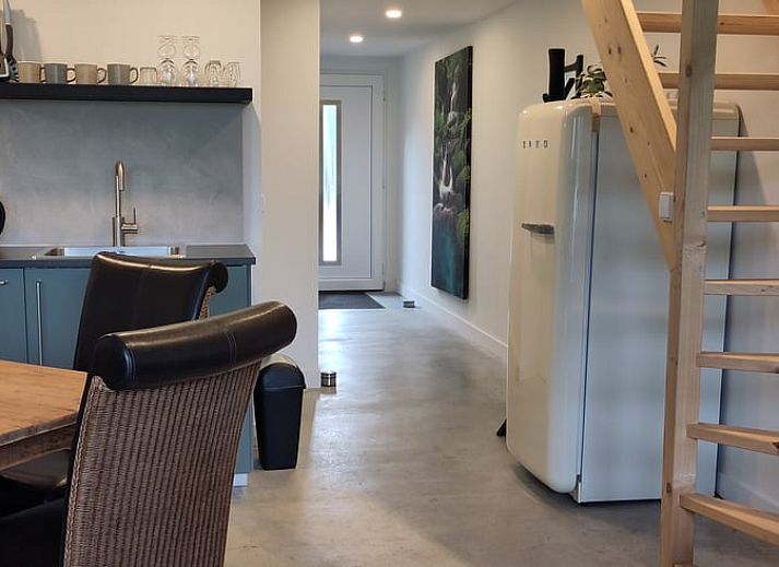 Gemuetlicher Innenbereich des Huisje in Rucphen, Ferienhaus in Westbrabant, mit Holztreppe, moderner Kueche und Essbereich.