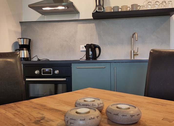 Gemuetlicher Innenbereich des Huisje in Rucphen, Ferienhaus in Westbrabant, mit Holztreppe, moderner Kueche und Essbereich.