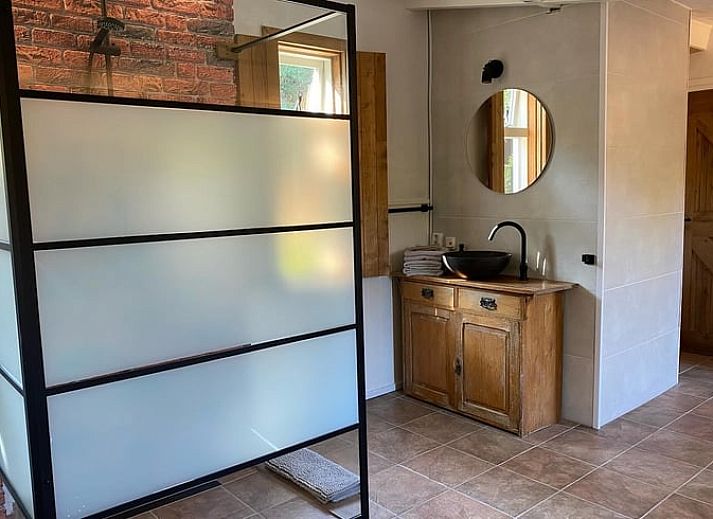 Geraeumige Sitzecke im Cottage in Hoogerheide, Ferienhaus in Hoogerheide, mit Ledersesseln und einem Fernseher.