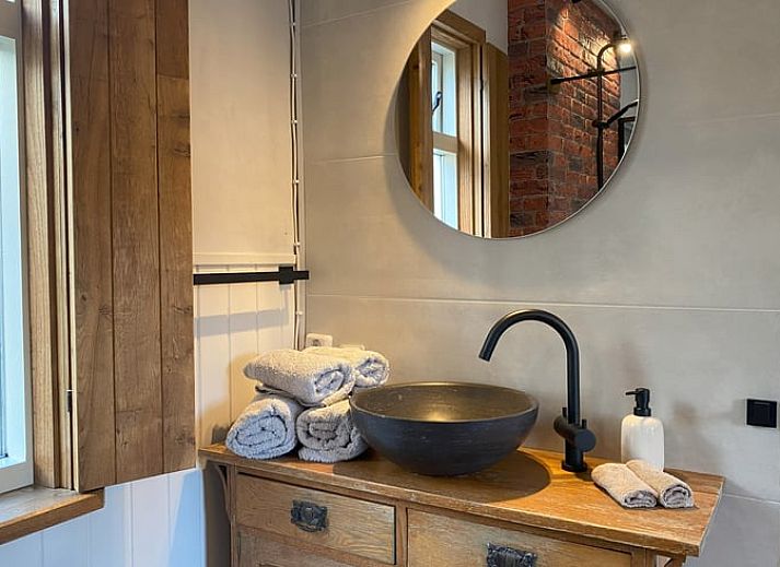 Geraeumige Sitzecke im Cottage in Hoogerheide, Ferienhaus in Hoogerheide, mit Ledersesseln und einem Fernseher.