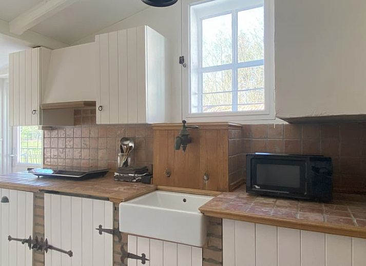 Geraeumige Sitzecke im Cottage in Hoogerheide, Ferienhaus in Hoogerheide, mit Ledersesseln und einem Fernseher.