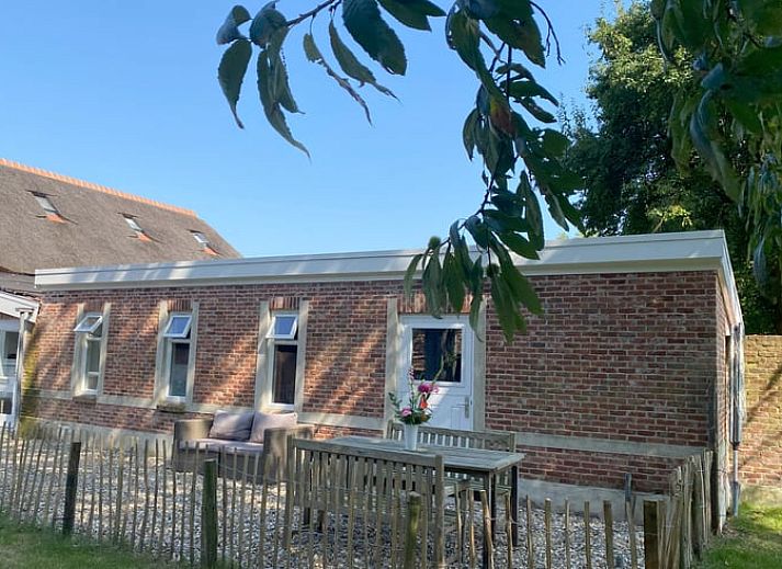 Helles Wohnzimmer im Ferienhaus in Hoogerheide, Nordbrabant, mit Sonnenblumen und Ledersesseln.