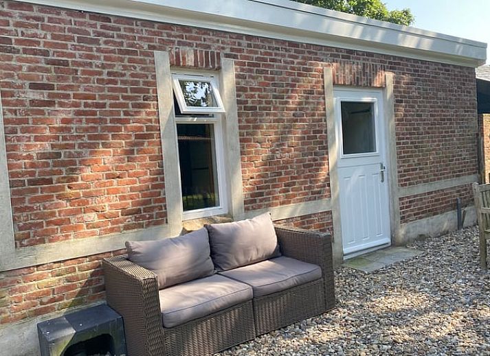 Helles Wohnzimmer im Ferienhaus in Hoogerheide, Nordbrabant, mit Sonnenblumen und Ledersesseln.