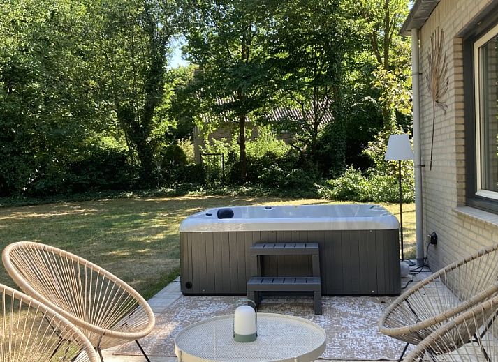Stijlvolle woonkamer in Villa Wellness Retreat, een vakantiehuis in Halderberge, Noord Brabant, met uitzicht op de groene natuur vanaf het terras.