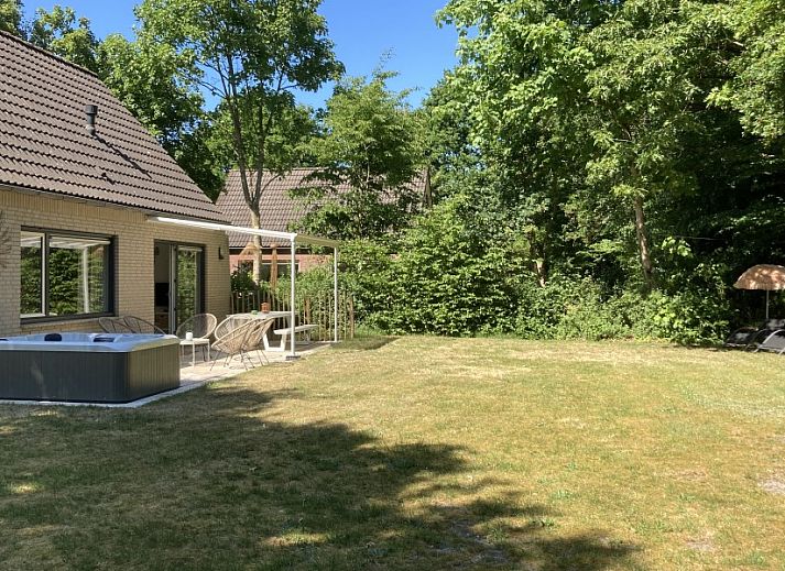 Stijlvolle woonkamer in Villa Wellness Retreat, een vakantiehuis in Halderberge, Noord Brabant, met uitzicht op de groene natuur vanaf het terras.